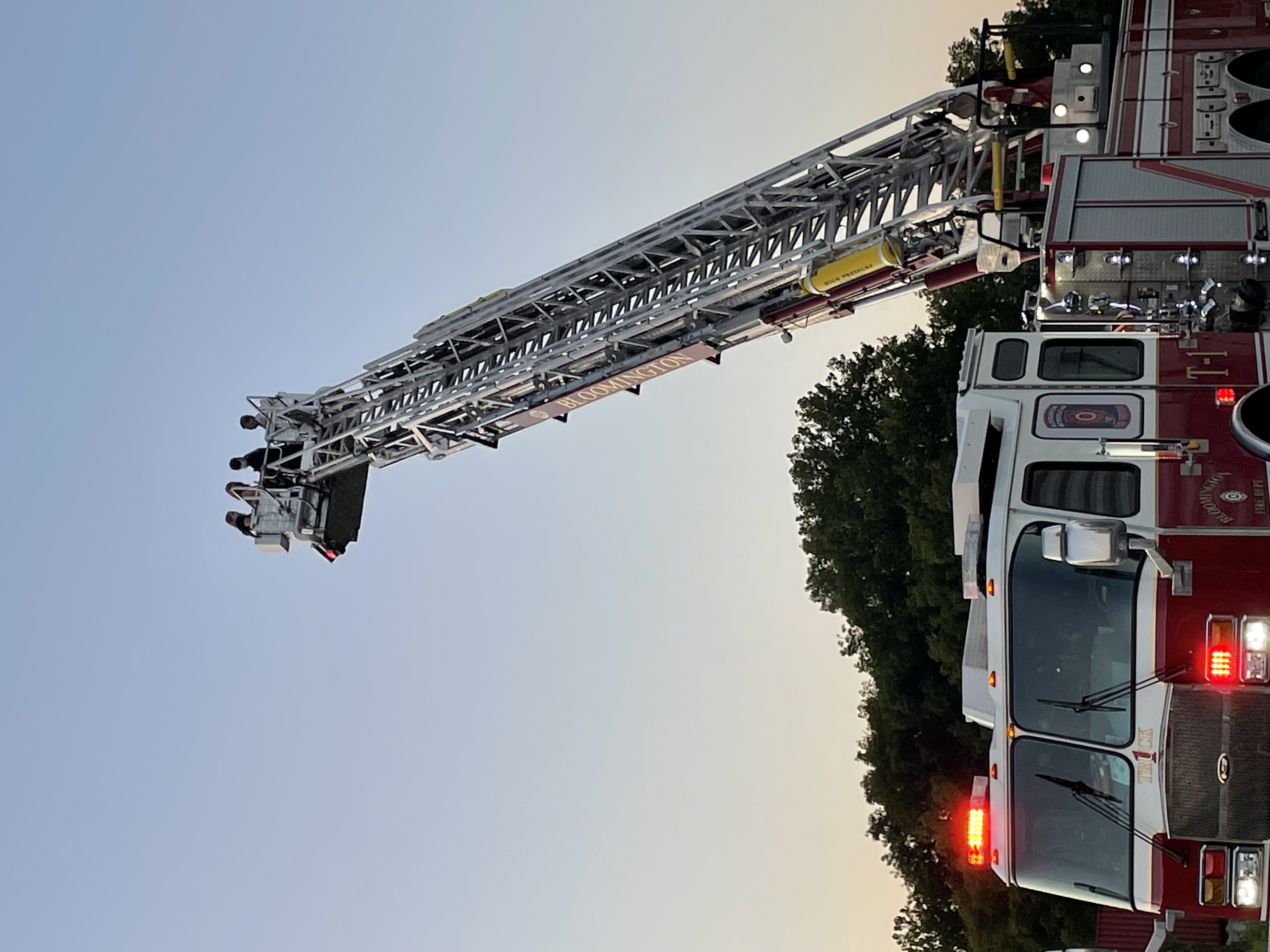2021 Residents Academy participants ride in the bucket of the 100' aerial ladder truck