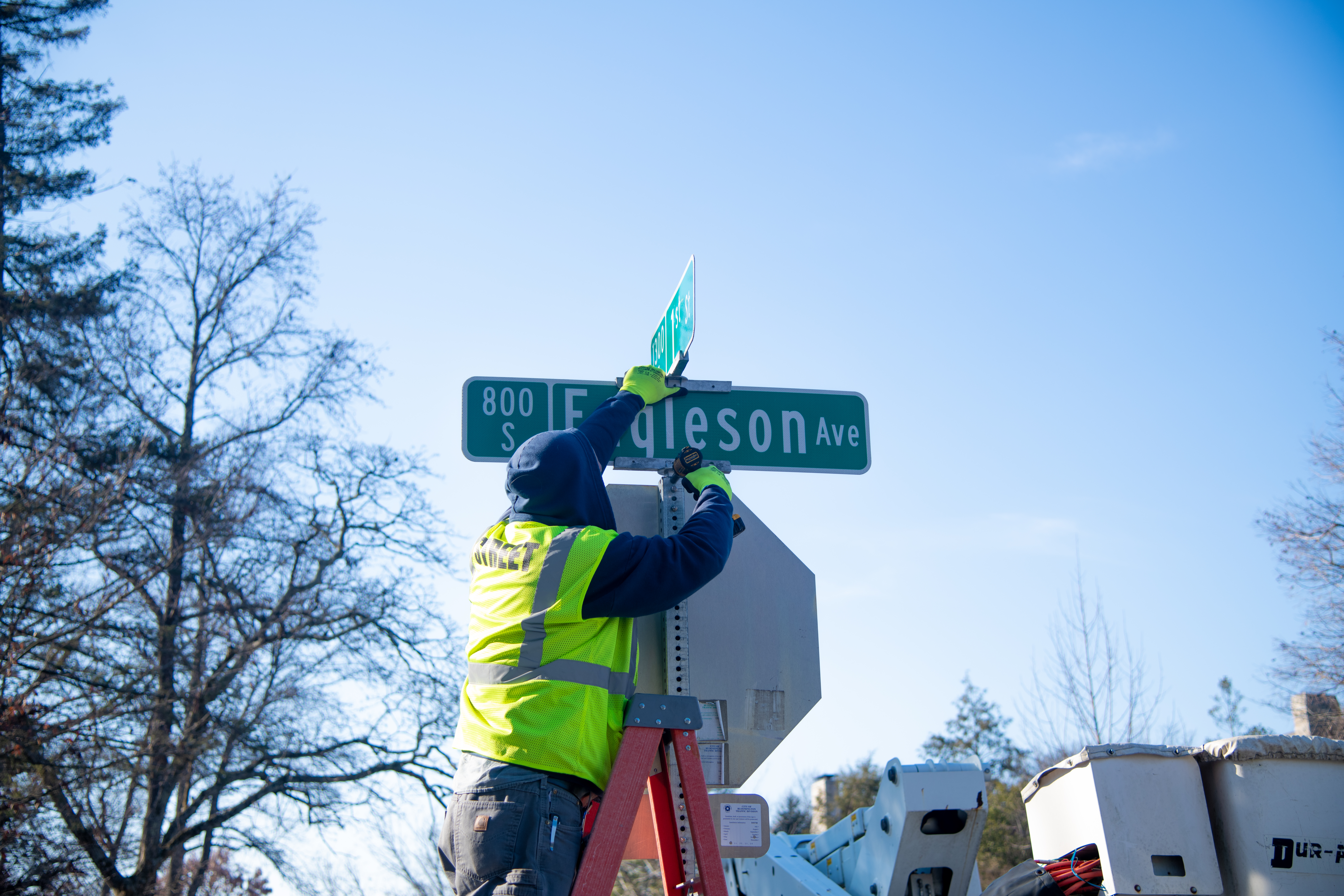 Street Division crew member Jason Kerr installs a new sign at the corner of 1st Street.