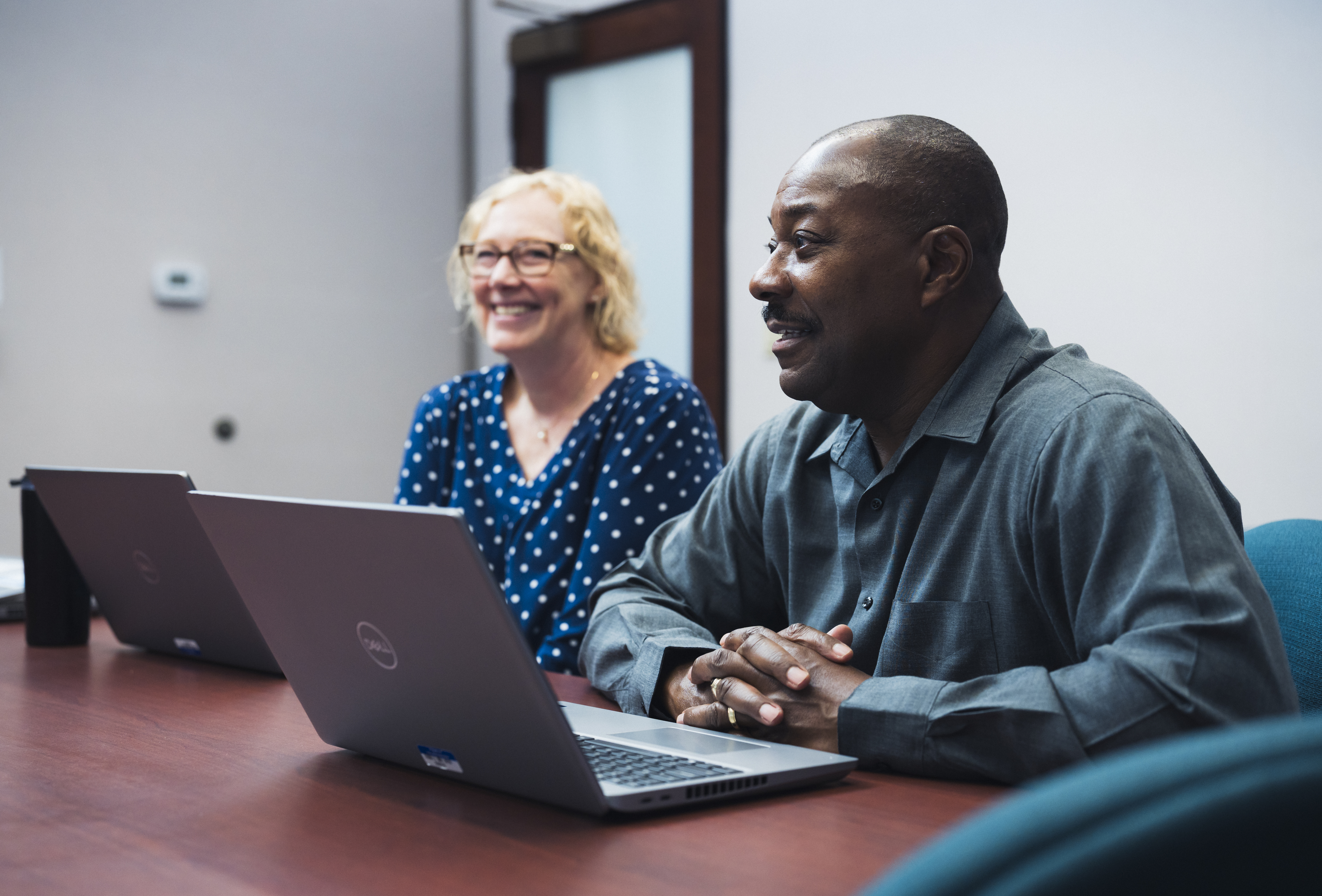 two happy employees sitting at a table