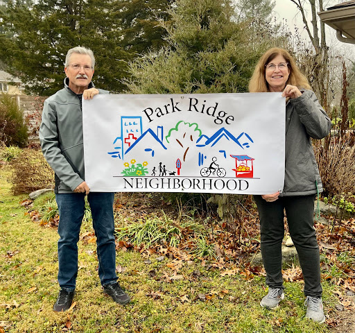 Park Ridge neighbors hold a banner depicting their neighborhood association logo.