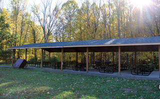 Photo of the picnic shelter at Winslow Woods taken in the fall, showing the picnic tables and trees with fall leaves in the background