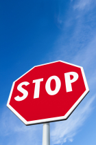 Stop sign against bright blue sky.